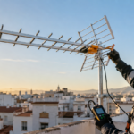 Instalador orientando una antena TDT con un medidor de campo